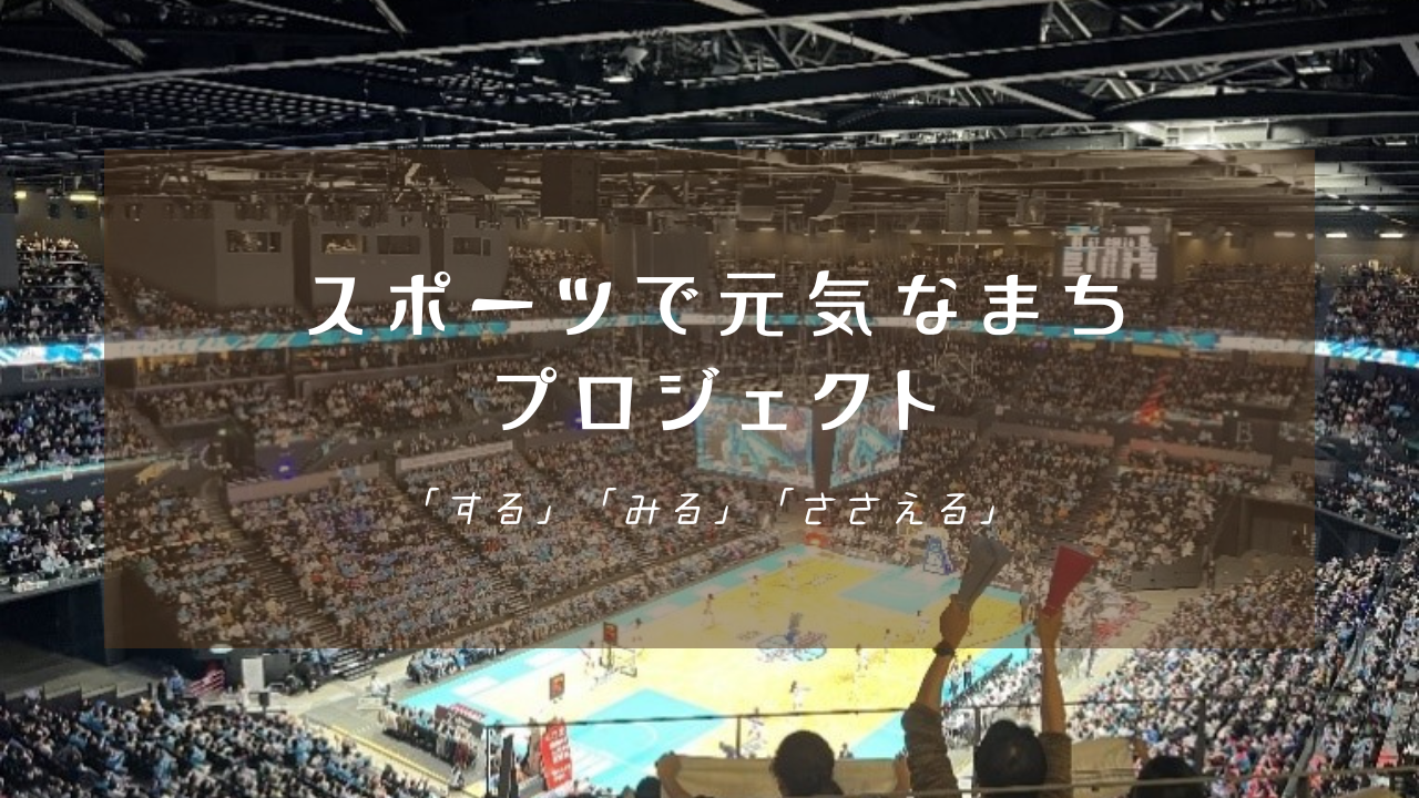 観客で埋め尽くされた巨大な屋内アリーナの試合風景を背景に、「スポーツで元気なまち プロジェクト 『する』『みる』『ささえる』」という白い文字が中央に配置された写真