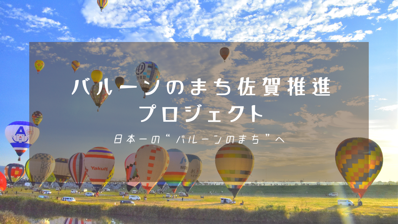 夕焼けに染まる青空を背景に色とりどりの多くの熱気球が浮遊する光景が広がり、「バルーンのまち佐賀推進プロジェクト 日本一の“バルーンのまち”へ」という白い文字が中央に配置された写真