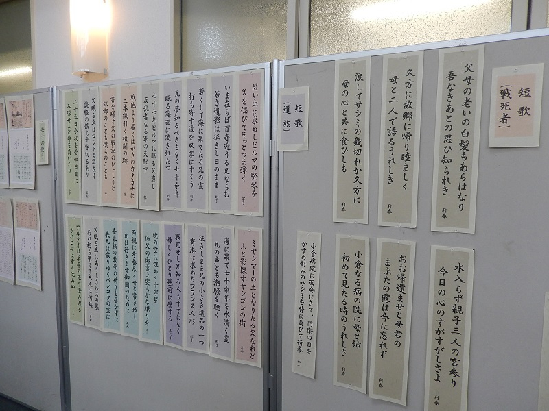 グレーの展示パネルに「短歌(戦死者)」や「短歌(遺族)」と題されたコーナーがあり、戦地から届いた便りや故人を偲ぶ切実な思いが詠まれた多数の短冊が、淡い色付きの台紙に貼られて整然と掲示されている展示風景の写真