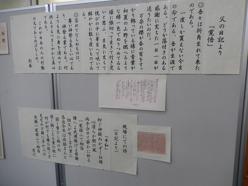 グレーの展示パネルに、出征した父の日記から引用された「覚悟」と題した文章や、戦地で詠まれた詩が大きな文字で書き起こされて掲示されており、その傍らには元となった日記の原本と思われる小さな資料も添えられている写真