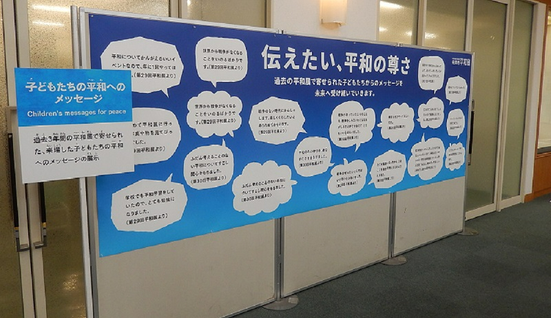 「伝えたい、平和の尊さ」という大きな見出しのもと、過去の平和展で寄せられた子供たちのメッセージが多数の吹き出しで紹介されている青色の展示パネルの写真