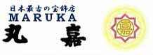 日本最古の宝飾店を示す「MARUKA」の文字と丸嘉の筆文字および紋章風の金色エンブレムが並ぶ株式会社丸嘉のロゴマーク