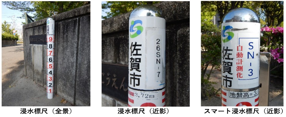 コンクリート壁の前に設置された1から9までの赤い目盛り付きの白い円柱ポールと、その上部に記載された佐賀市のロゴや管理番号、自動計測化のラベルを順に示した写真