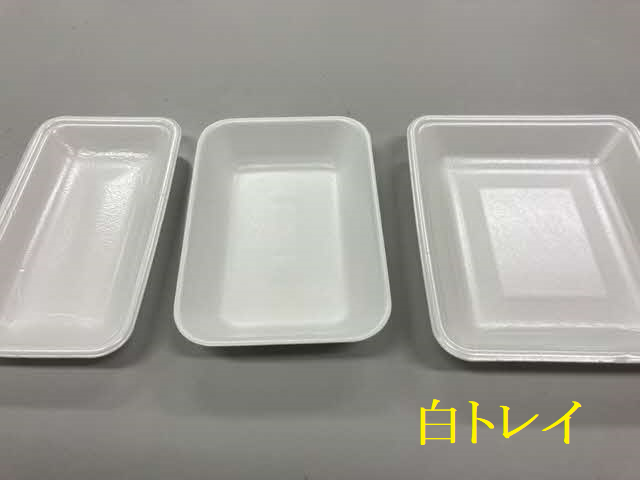台の上に、リサイクル回収の対象となる真っ白なプラスチック製食品トレーが、大きさや形の異なる3種類横一列に並べられ、右下に黄色い文字で「白トレイ」と書かれた