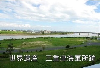 「世界遺産 三重津海軍所跡」の文字と広々とした緑地と穏やかに流れる川を望む風景の写真