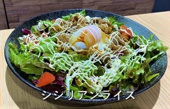 シシリアンライスの文字と、皿に盛られたレタスやトマトなどの生野菜の上に焼いた肉とマヨネーズがかけられ、中央に温泉卵が乗った「シシリアンライス」の写真