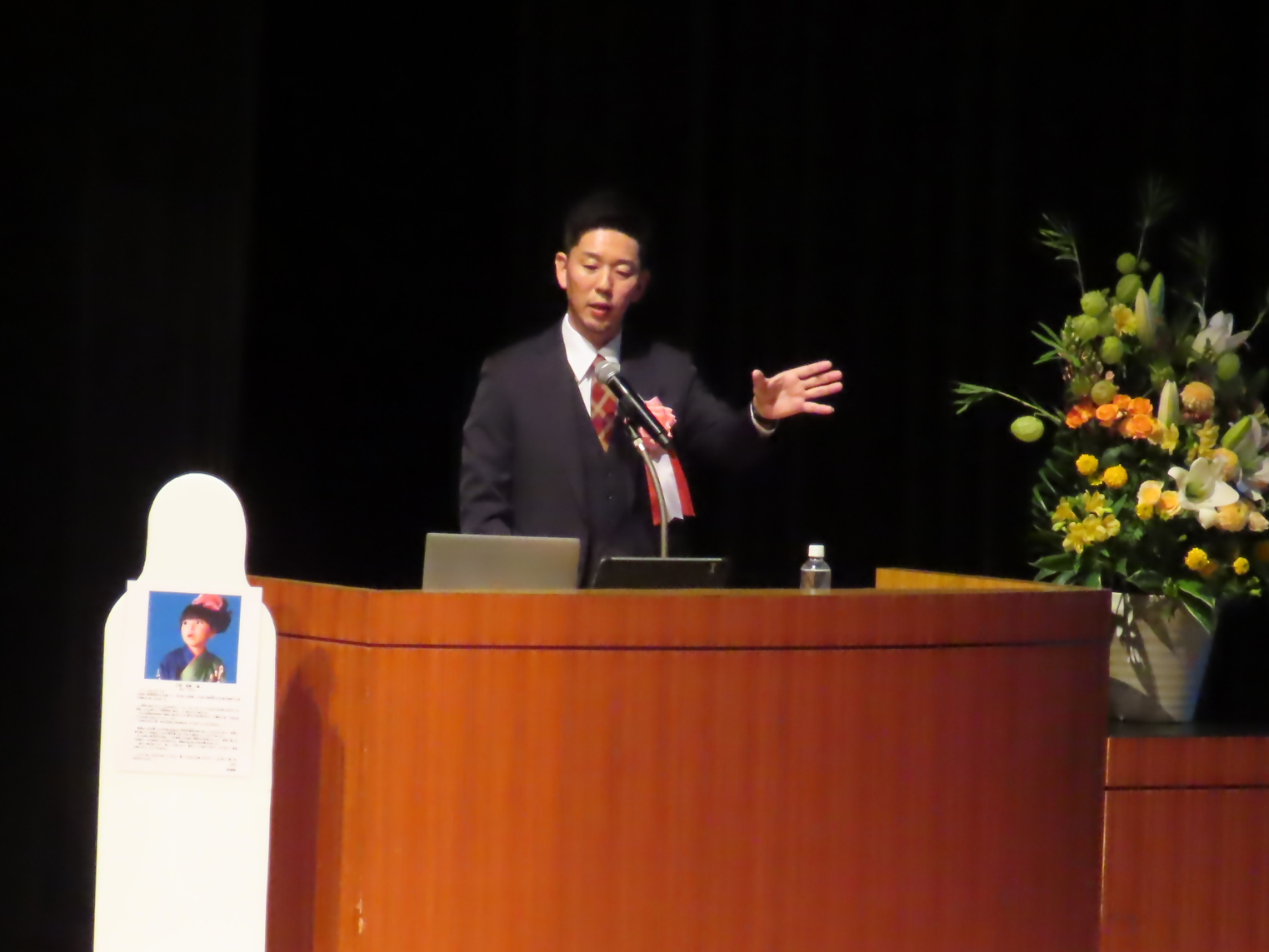 演台に立ち、基調講演を行っている小谷真樹氏の様子を写した写真
