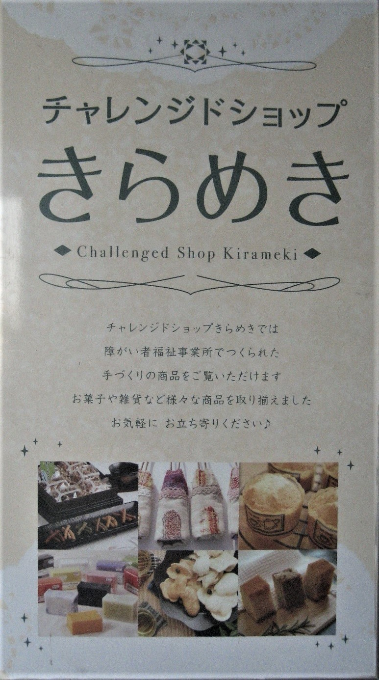 「チャレンジドショップ きらめき」と書かれ、障がい者福祉事業所の手作り商品を紹介する説明文とともに、お菓子や雑貨、石鹸などの商品写真が複数並べられている看板の写真