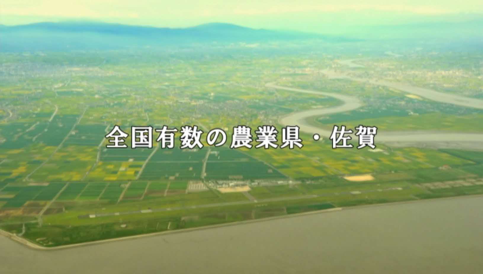 「全国有数の農業県・佐賀」という白いテロップが中央に配置され、眼下に広大な緑の田畑と緩やかに流れる河川、そして遠くに霞む山々を一望する空中写真が写された写真