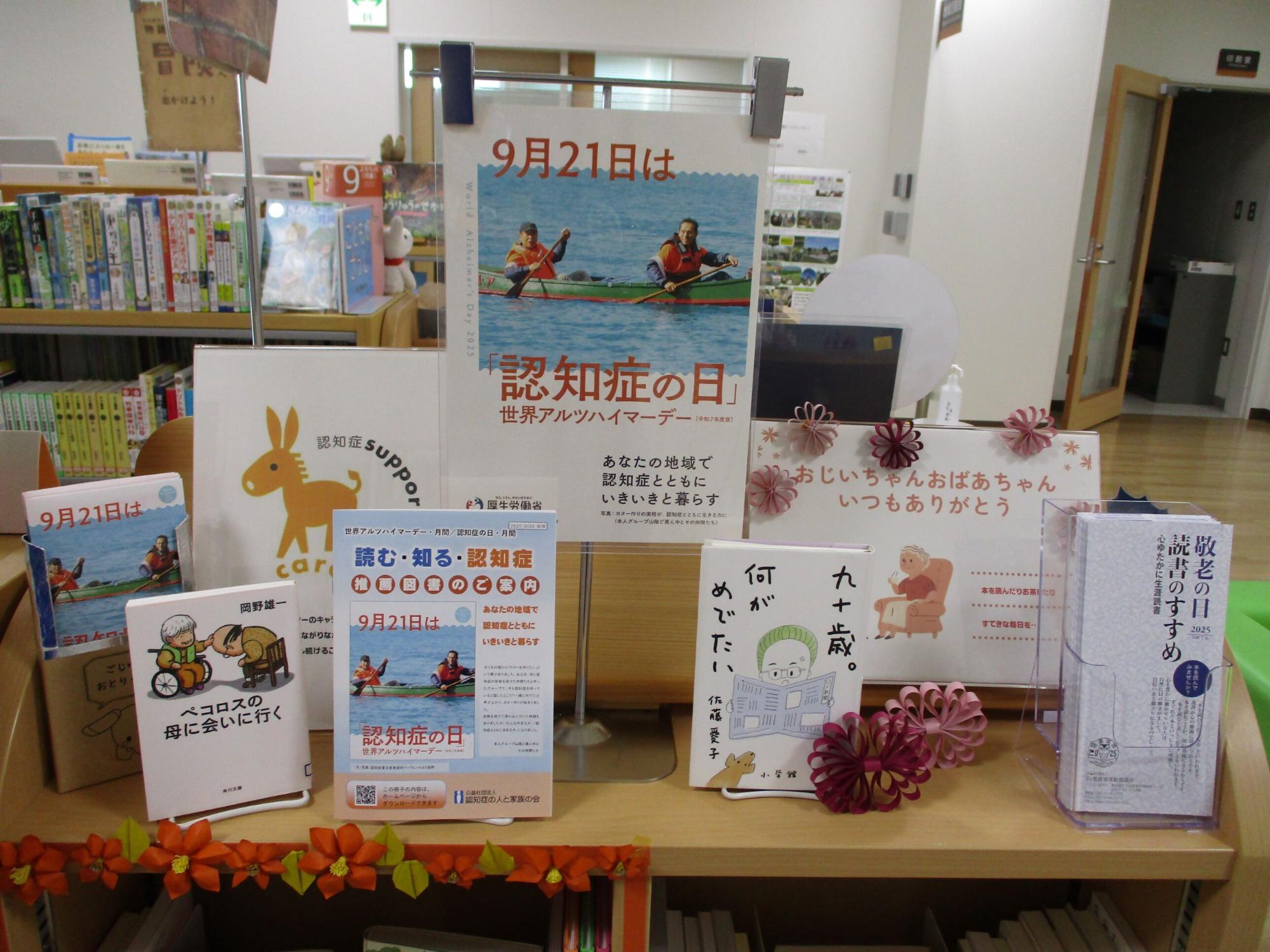 図書館の棚に、「9月21日は認知症の日 世界アルツハイマーデー」であることを知らせるポスターや、「認知症に関する推薦図書の案内」が掲載されたパンフレット、認知症をテーマとした複数の書籍が並べられている特設コーナーの写真。