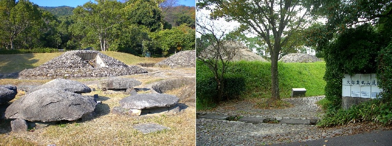 緑豊かな山裾の斜面に設置された、白いコンクリート製のドーム状の構造物が複数並ぶ遺跡を、手前の木々の枝越しに捉えた写真