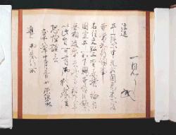 薄茶色の和紙に墨で文字が整然と書き連ねられ、末尾には記述とともに流麗な黒い花押が据えられている正法寺文書を広げて撮影した写真