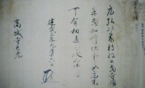 茶色く変色した古い和紙の上に、力強く伸びやかな墨の筆致で文字が記され、左下には独特の形状をした黒い花押が据えられた高城寺文書の写真