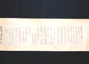 薄茶色の横長の紙に、端正な筆致で書かれた黒い墨書きの漢字が右から左へと整然と並び、左端には小さな署名が記された旅日記の巻物の写真
