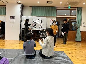 子ども達が書道の先生から、書道の作品について添削を受けている