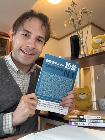 ニックが自宅で日本語能力試験の本を持っている写真