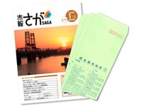 表紙に夕焼けと工場のシルエットが印刷された市報さがの冊子と、緑色の背景に文字が印刷された封筒が並んで配置されている写真