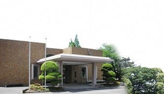 正面には白い大きな庇が突き出した車寄せがあり、茶色のタイル貼りの外壁を持つ落ち着いた雰囲気の桂寿苑の外観写真