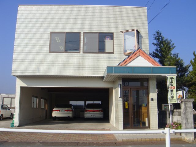 薄いグレーのタイル壁が特徴的な2階建ての有限会社 ケンショーハウス工業の建物外観写真