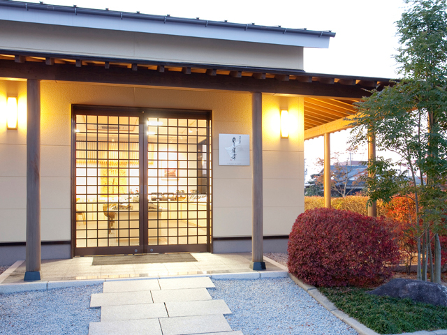 格子戸の引き戸から漏れる温かな光が印象的な平屋の和風建築の三福海苔の外観写真
