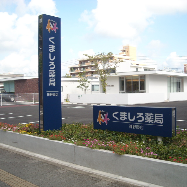 白を基調としたモダンで清潔感のある平屋建ての「くましろ薬局神野東店」の店舗外観写真