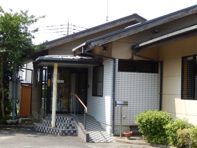 落ち着いたベージュ色の外壁を持つ平屋建ての栗林歯科医院の外観写真