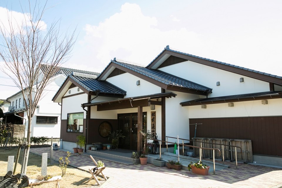 瓦屋根と白い壁面が特徴的な平屋建ての和風建築で、入り口には「肥前通仙亭」と書かれた看板が掲げられている写真