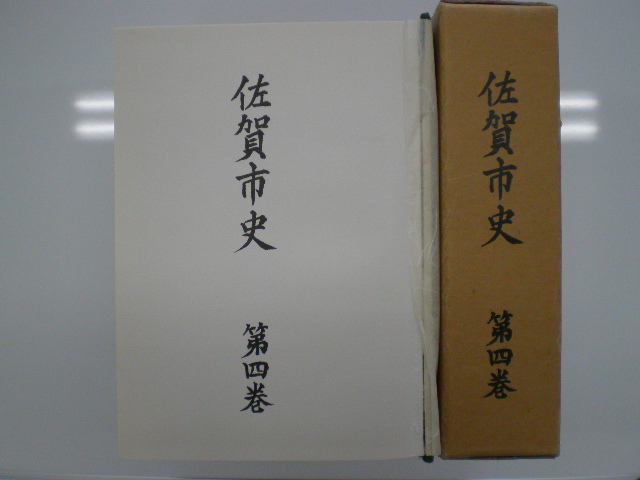 茶色の函に佐賀市史第四巻と縦書きされた背表紙と、開かれた白い表紙ページに佐賀市史第四巻の文字が見える佐賀市史(第四巻)の写真