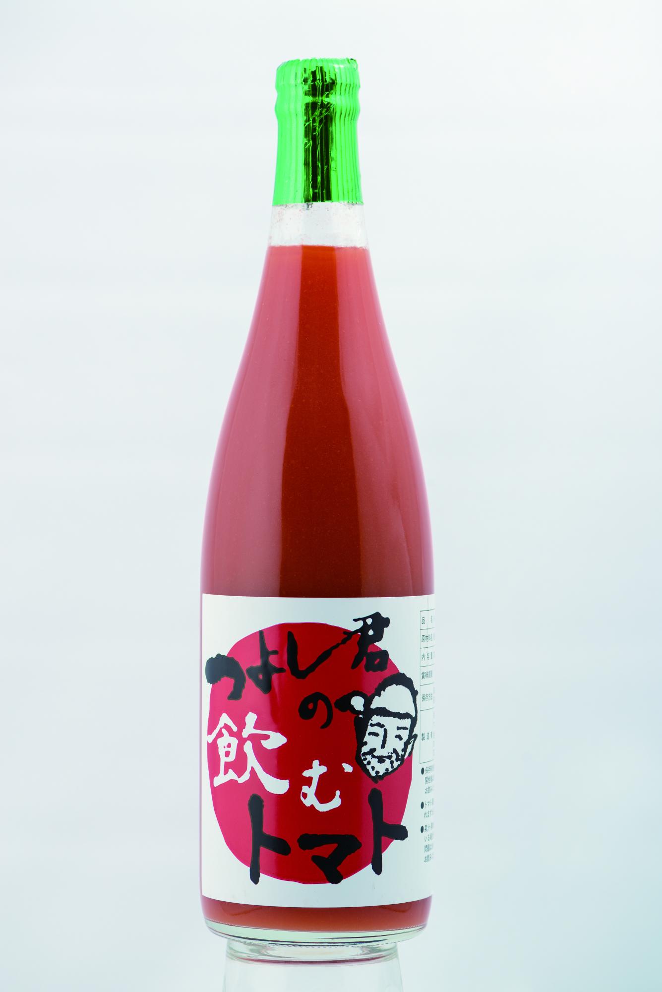 大きな赤い円の中に「つよし君の飲むトマト」という墨文字と男性の似顔絵がデザインされたラベルが貼られ、鮮やかな赤色のトマトジュースが入ったグリーンのキャップシールが特徴的なガラスボトルの商品の写真