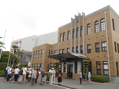戸上電機製作所本館の前で見学する参加者の様子。