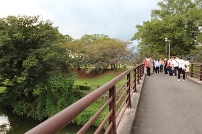 公園内の橋の上から石井樋を見学する参加者の様子。
