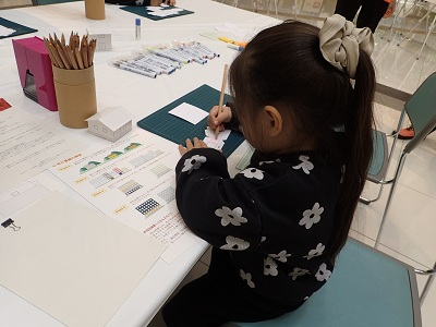 ジオラマシートに色鉛筆で色を塗る子どもの様子