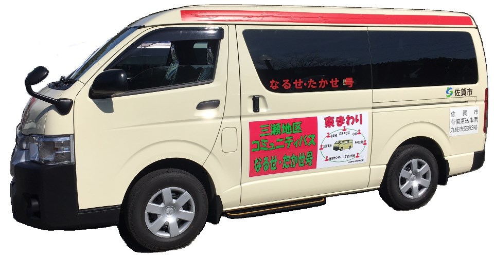 淡いクリーム色の車体に赤帯と地域コミュニティバスの案内表示が施されたワゴン車が横向きに停まっている写真