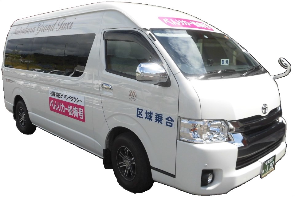白い車体に地域デマンドタクシーの案内表示が貼られたワゴン車が斜め前方から写されている写真