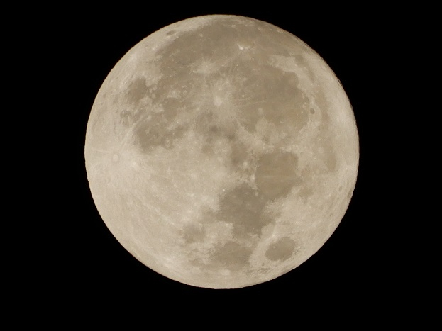 漆黒の夜空の中央に、無数のクレーターや陰影がくっきり見える白灰色で丸い満月が浮かんでいる写真