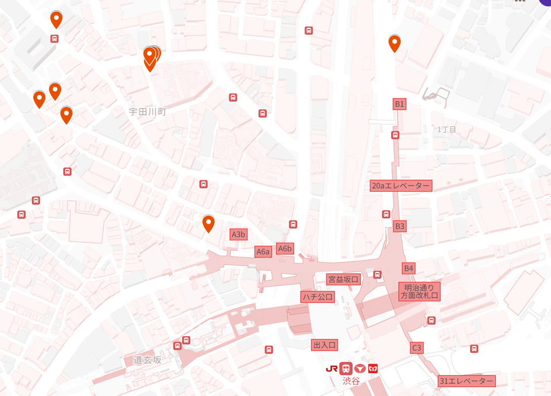 渋谷駅周辺の市街地地図上にオレンジ色のピンや駅の出入口番号が示され、道玄坂や宇田川町といった地名と共にJR線や地下鉄の路線記号が配置された、目的地や周辺施設の位置関係を確認するための案内地図
