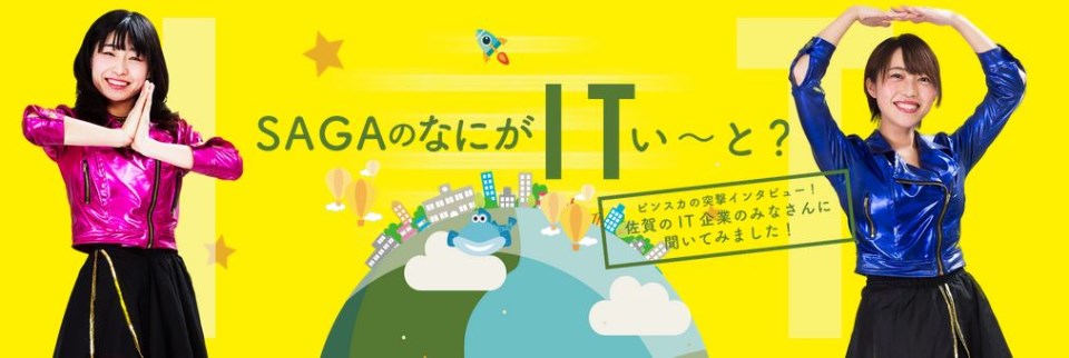 鮮やかな黄色の背景に、ピンクと青のメタリックな衣装を着た二人の女性が笑顔でポーズをとり、中央には「SAGAのなにがITい〜と？」という文字と地球や街並みのイラストが描かれた、ポップなデザインの画像