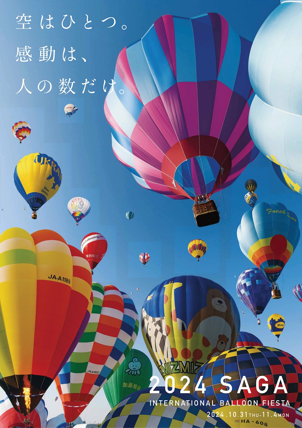 抜けるような青空を背景に、赤や青、黄色など色とりどりの模様や、動物が描かれた巨大な熱気球が空いっぱいに広がり、「空はひとつ。感動は、人の数だけ。」というキャッチコピーを添えた、2024佐賀インターナショナルバルーンフェスタのポスター