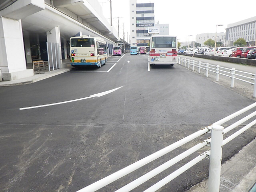 高架下の広い乗降エリアに白い柵が長く続き奥では複数の路線バスが停車して静かな雰囲気を見せる様子の写真
