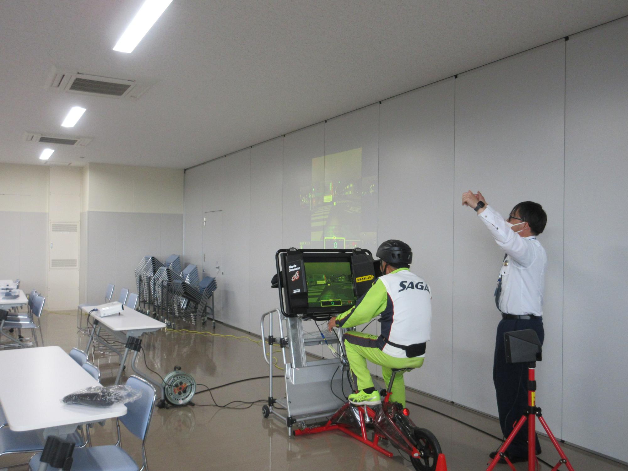 室内で参加者が自転車シミュレーターに乗って走行訓練を行っている様子の写真