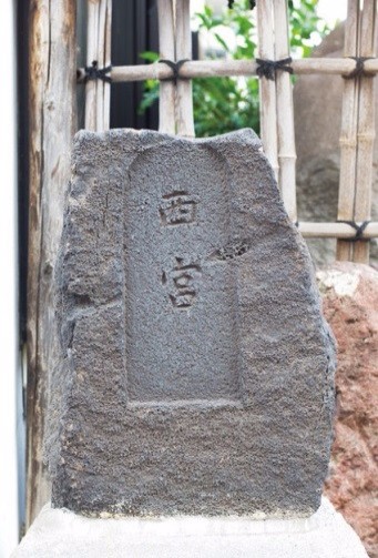 「西宮」の文字が刻まれ、周囲の竹垣や石とともに静かに佇む石碑の写真
