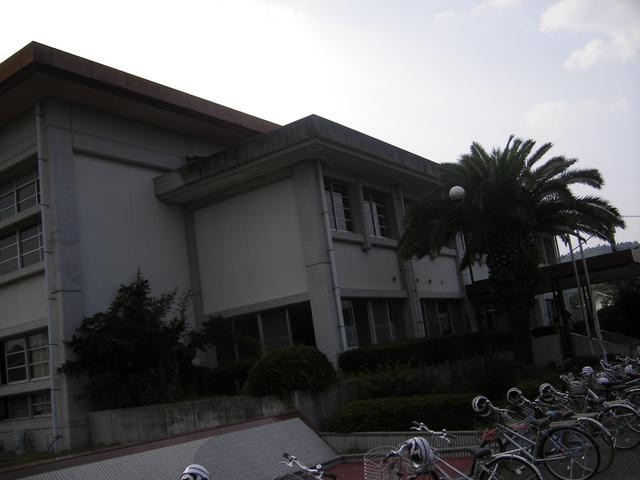 薄暗い空の下に建つコンクリート造りの無機質な二階建ての佐賀市立大和勤労者体育センターの外観写真