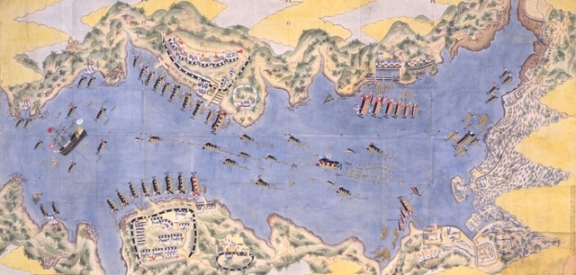広大な青い海を舞台に、帆を張った軍艦や数多くの小舟が整然と隊列を組み、海岸沿いに築かれた陣地や建物を取り囲むように配備されている長崎港警備図の画像