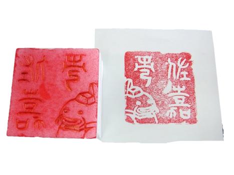 発泡スチロールで作られたハンコと、赤色でスタンプされたハンコの印面の画像