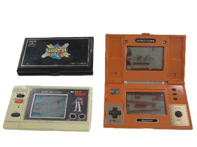 左上に黒いゲームウォッチ、左下にガンダムのゲームウォッチ、右側に折り畳みを広げたオレンジ色のゲームウォッチの画像