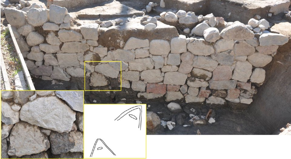 掘り起こされた「牛嶋口跡」の北面石垣の全景と、表面に「A」のような形状の刻印がある石垣の一部を黄色の枠で拡大し、その刻印を線画で書き起こした図を並べて示した現場写真。