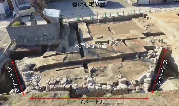 「佐賀城下東入口 牛嶋口跡」の遺構を斜め上から捉え、発掘された石垣の規模を「5メートル」「7メートル」「6メートル」という赤い両矢印と白い文字で示した、橋土台の構造が露出している現場写真