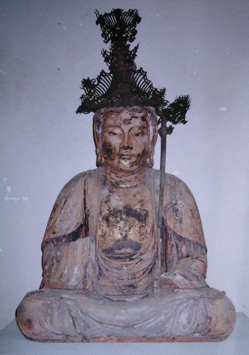 精緻な金属冠を戴き長い錫杖を携えた木彫坐像が古色を帯びた衣文をまとい堂々と安置され静かに威厳を放つ写真
