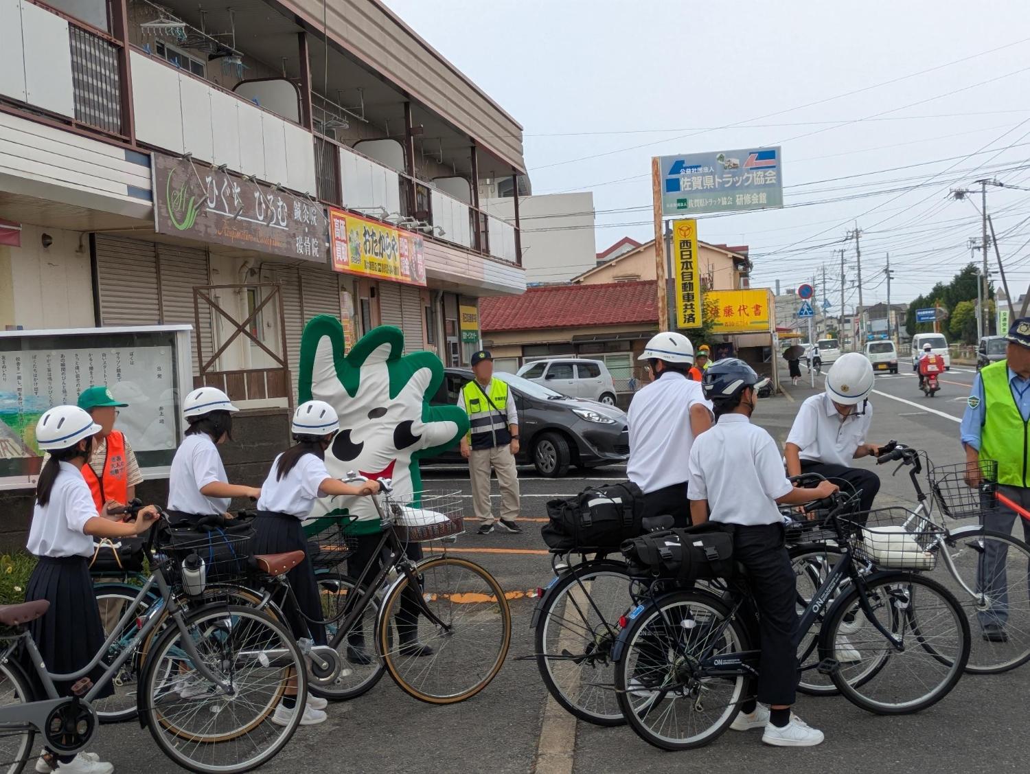 中学校の校門付近で、中学生の下校を、地区の青少年健全育成会の会員が安全確保のため、見守り活動を行っている。